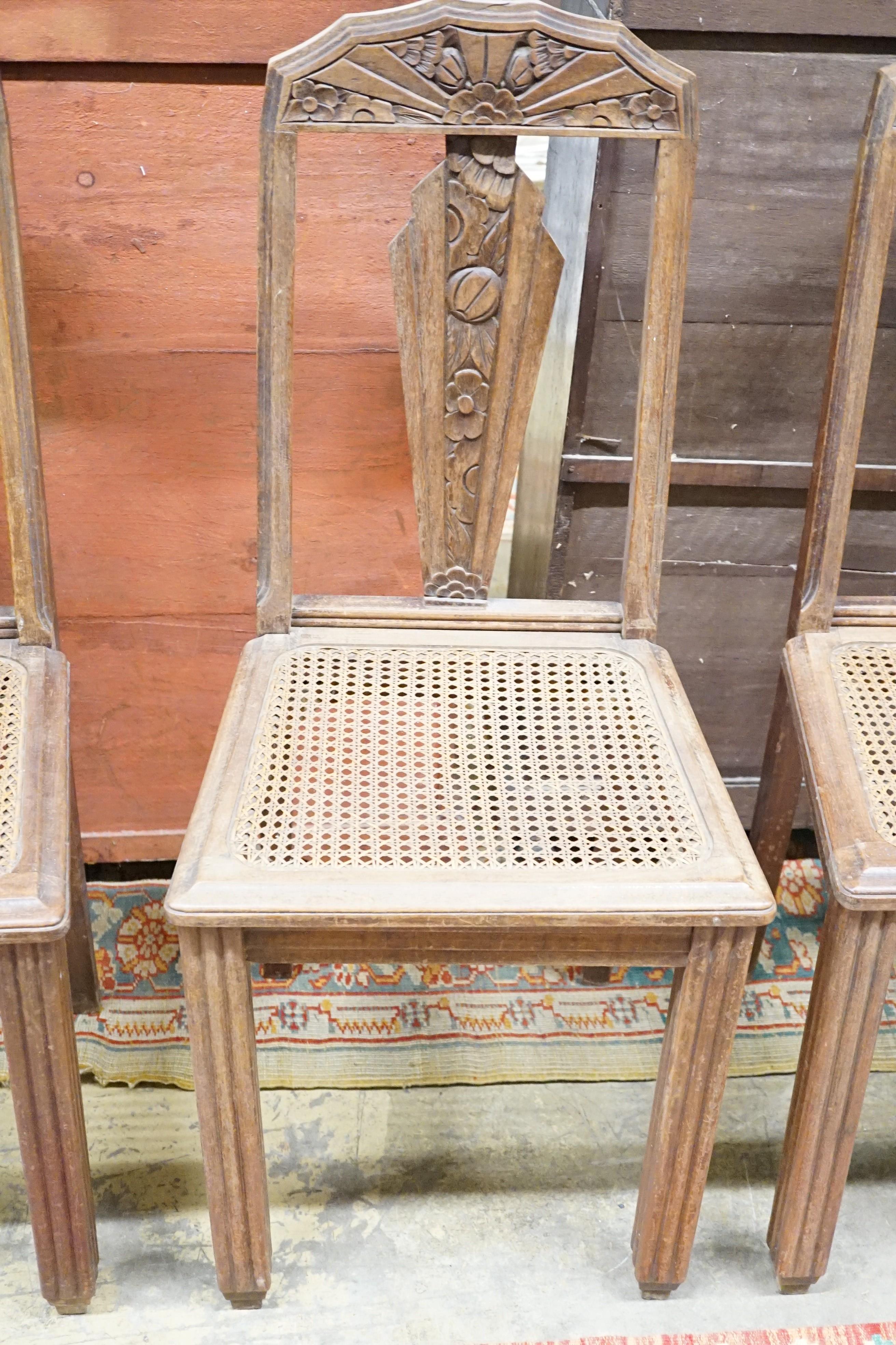 A set of six Continental Art Deco carved and stained beech salon chairs with caned seats, width 44cm, height 96cm